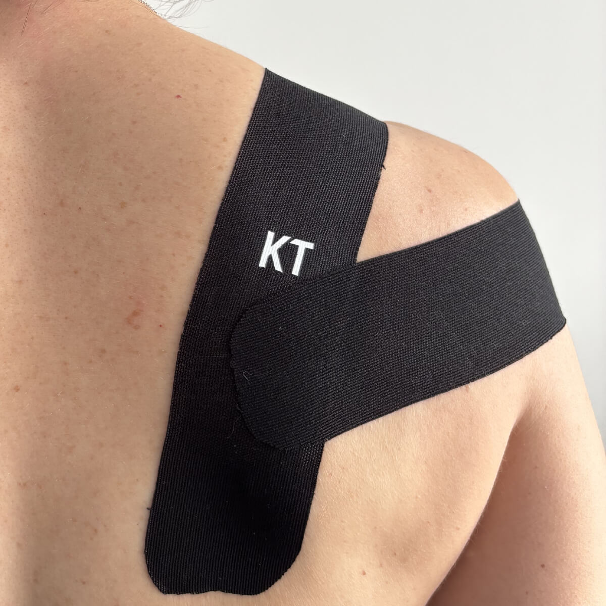 Kinesio tape aan de achterzijde schouder voor houdingcorrectie
